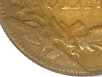 1869 Indian Head penny reverse cud variety showing raised metal blob from die break between 2:30 and 3:30 o'clock position